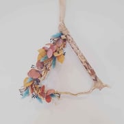 A triangular shaped brightly coloured dried flower wreath