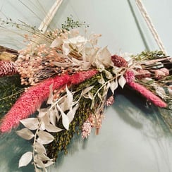 A close up of a triangular shaped display of mixed dried flowers